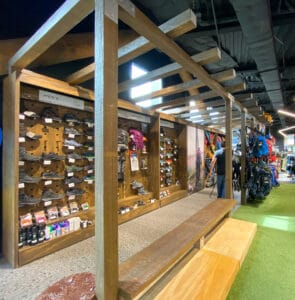 Freestanding footwear wall with puck display and seating made with natural wood and plywood